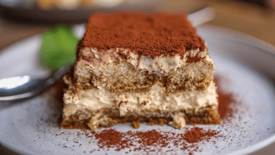 Delicious tiramisu dessert with creamy layers and a dusting of cocoa powder on a white plate