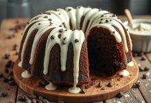 Perfectly moist chocolate chocolate chip bundt cake topped with a rich drizzle of chocolate ganache, served on a white plate for a decadent homemade dessert.