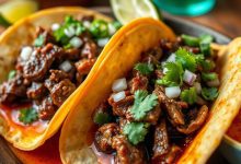 Crispy birria tacos served with hot consommé, garnished with fresh lime, onions, and cilantro, perfect for an authentic Mexican food experience