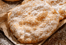 Golden, freshly fried dough sprinkled with powdered sugar, perfect for recreating a classic fairground dessert at home.