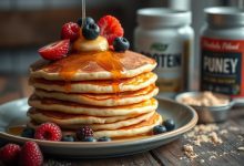 Delicious stack of protein pancakes on a white plate, topped with fresh blueberries, a drizzle of maple syrup, and a sprinkle of powdered sugar, highlighting a healthy and nutritious breakfast option