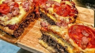 Homemade pizza burger pie with a crispy golden crust, gooey melted cheese, seasoned ground beef, and colorful pizza toppings, perfect for a hearty and flavorful meal