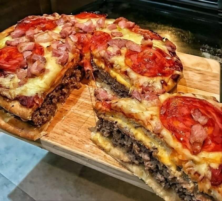 Homemade pizza burger pie with a crispy golden crust, gooey melted cheese, seasoned ground beef, and colorful pizza toppings, perfect for a hearty and flavorful meal